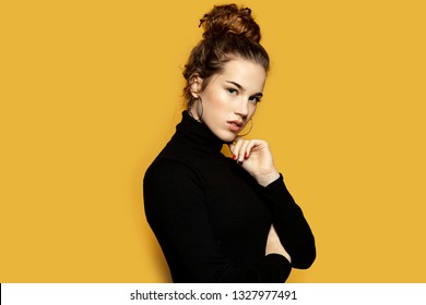 Portrait of fascinating girl feeling comfy in pretty pullover. Winter and fashion concept. Attractive woman with brunette hairstyle on yellow background