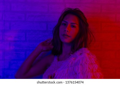 Portrait fashion of an Asian woman in neon-violet and red light  that shines in the dark with beauty and sexy, seductive, charming, concept of beauty of neon lights and young women,studio shot .