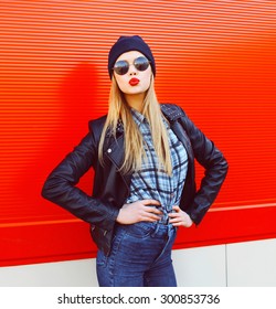 Portrait Of Fashionable Blonde Woman Blowing Lips With Red Lipstick Wearing A Rock Black Style Having Fun In The City