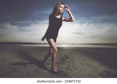 Portrait of fashionable girl running at the seaside .Fashio colors.Vogue style photo of fashion lady. Wide angle. 