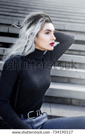 Portrait of fashionable young woman with white hair and dark lipstick in dark clothes. Autumn style