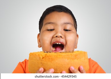 Portrait Of A Fat Asian Boy Eating Big Piece Of Cake