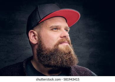 Portrait of fat bearded male dressed in a jacket and baseball cap.