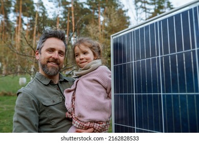 Portrait of father and daughter holding a solar panel in garden. - Powered by Shutterstock