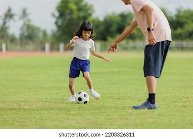 Portrait Father And Daughter, A Young Girl Who Is Cute Father Teaching Daughter To Play Soccer In The Field On Vacation It Is An Outdoor Activity That Allows A Happy Family To Exercise And Learn.