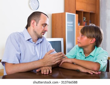 Portrait Of Father And His Teenager Son Having Serious Conversation At Home
