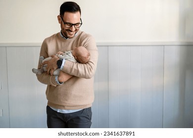 Portrait of a father hugging and kissing newborn baby. Authentic lifestyle touching tender moment. - Powered by Shutterstock