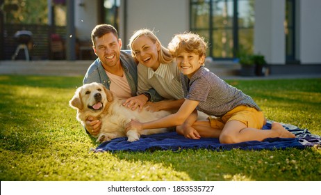 Portrait of Father, Mother, and Son Having Picnic on the Lawn, Posing with Happy Golden Retriever Dog. Idyllic Family Have Fun with Loyal Pedigree Doggy Outdoors in Summer House Backyard. - Shutterstock ID 1853535727