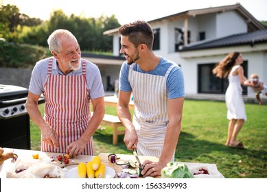 Portrait Of Father And Son Outdoors On Garden Barbecue, Grilling.