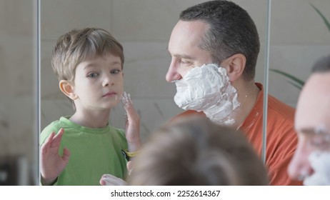 Portrait of father and son shaving together in mirror, learn about man hygiene - Powered by Shutterstock