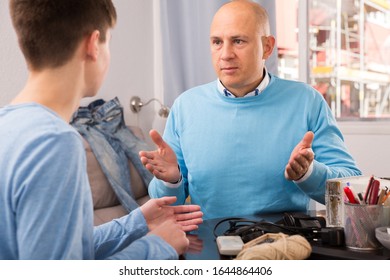 Portrait Of Father Talking To Teenage Son, Having Friendly Conversation At Home