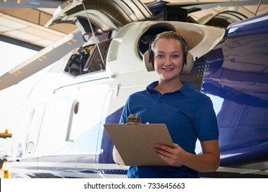 Portrait Of Female Aero Engineer With Clipboard Carrying Out Check On Helicopter In Hangar - Powered by Shutterstock