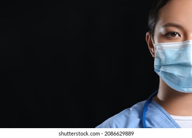 Portrait Of Female Asian Doctor In Medical Mask On Dark Background