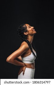 Portrait Of A Female Athlete On Black Background. Smiling Fit Woman Relaxing After Workout.