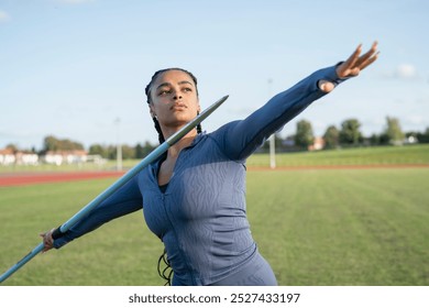 Portrait of female athlete throwing javelin - Powered by Shutterstock