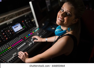 Portrait Of Female Audio Engineer Using Sound Mixer In Recording Studio