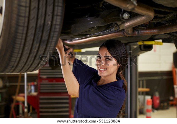 Portrait\
Of Female Auto Mechanic Working Underneath\
Car