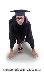 Portrait of female bachelor posing to race and compete while wearing graduation gown