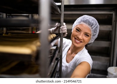 Portrait of female baker in white clean uniform and hairnet preparing bread in bakery production. - Powered by Shutterstock