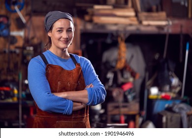 Portrait Of Female Blacksmith Wearing Headscarf Standing In Forge With Folded Arms - Powered by Shutterstock