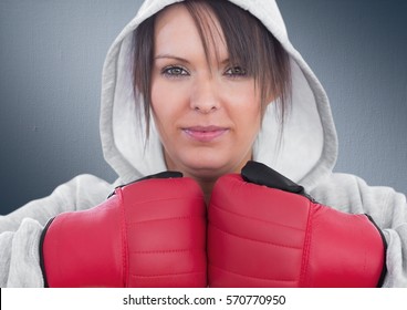 Portrait of female boxer wearing boxing gloves against grey background - Powered by Shutterstock