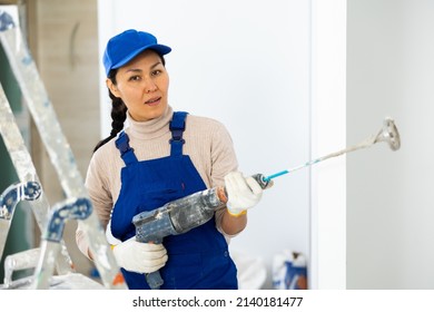 Portrait Of Female Builder With Paint Mixing Machine Indoors