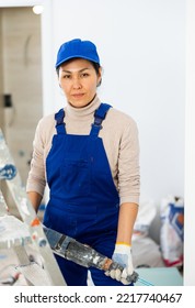 Portrait Of Female Builder With Paint Mixing Machine Indoors