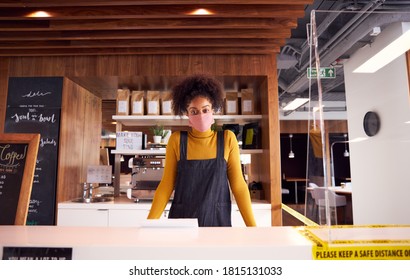 Portrait Of Female Business Owner Of Coffee Shop In Mask Behind Counter During Health Pandemic