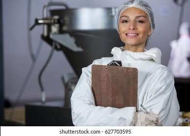 Portrait of female butcher holding clipboard at meat factory - Powered by Shutterstock