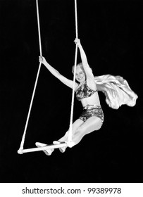 Portrait of a female circus performer performing on a trapeze bar