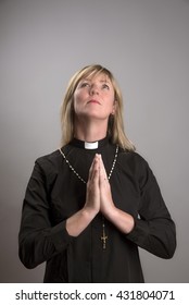 Portrait Of A Female Clergy Wearing A Clerical Collar,looking Up And Praying