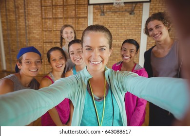 Portrait of female coach and high school kids taking a selfie - Powered by Shutterstock