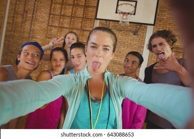 Portrait of female coach and high school kids taking a selfie - Powered by Shutterstock