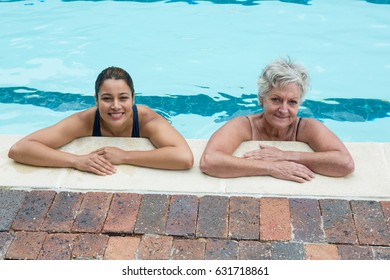 Portrait of female coach and senior woman leaning on poolside - Powered by Shutterstock