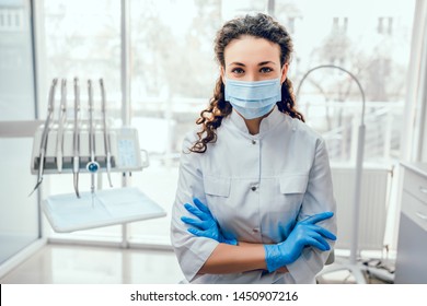 Portrait Of Female Dentist. She Standing At Her Office In Mask.