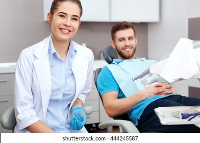 Portrait Of A Female Dentist And Young Happy  Male Patient In A Dentist Office.