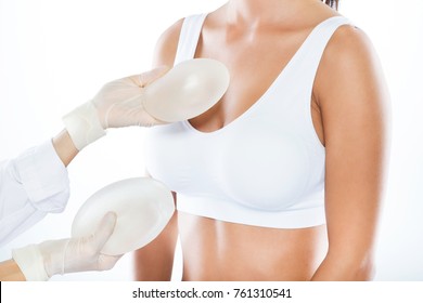 Portrait of female doctor choosing mammary prosthesis with her patient over white background. - Shutterstock ID 761310541
