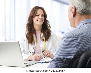 Portrait Of Female Doctor Consulting Her Old Patient At Hospital.