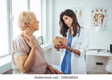 Portrait Of A Female Doctor Helping A Senior Woman At Office With Her Neck Injury A Healthcare And Medicine Concepts. Doctor Putting Neck Orthopaedic Collar On Adult Injured Woman