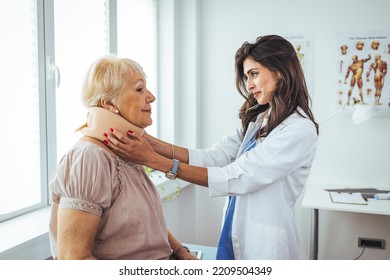 Portrait Of A Female Doctor Helping A Senior Woman At Office With Her Neck Injury A Healthcare And Medicine Concepts. Doctor Putting Neck Orthopaedic Collar On Adult Injured Woman