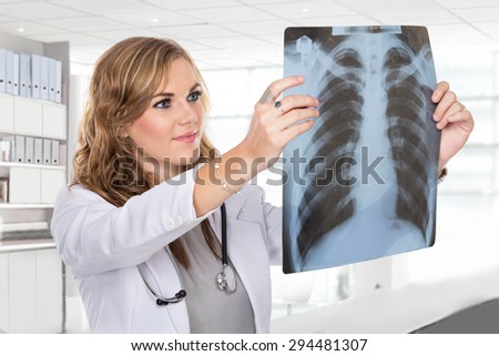 A portrait of a female doctor looking at a lungs or torso xray