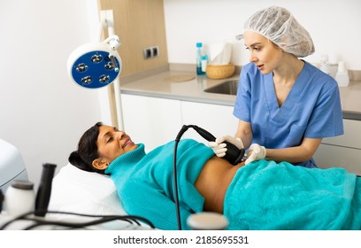 Portrait Of Female Doctor Performing Electroporation Mesotherapy Body Treatment To Woman At Aesthetic Clinic