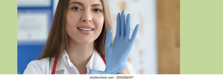 Portrait Of Female Doctor Putting On Medical Gloves