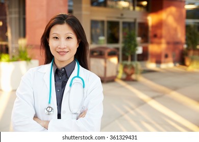 Portrait Of Female Doctor Standing Outside Hospital
