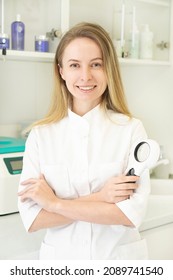 Portrait Of A Female Doctor Doctor Trichologist Dermatologist Holding A Magnifying Glass To Examine The Skin. Mole Diagnostics. Vertical