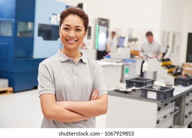 Portrait Of Female Engineer On Factory Floor Of Busy Workshop