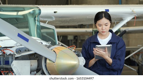Porträt von Ingenieuren oder Piloten mit Tablet-PCs, um Informationen für ihr Projekt zu recherchieren. Ingenieurinnen reparieren einen Düsenmotor mit Konzentration. Verkehr und Technologie