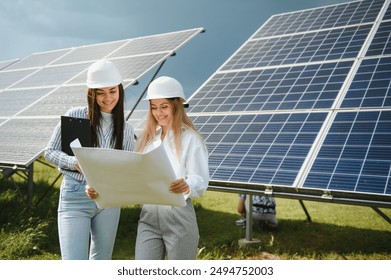 Portrait of female engineers spending time outside near solar panels. - Powered by Shutterstock