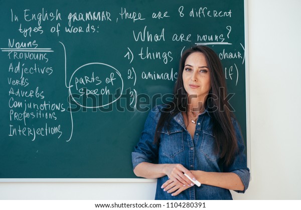黒板の前に女性の英語教師のポートレート の写真素材 今すぐ編集