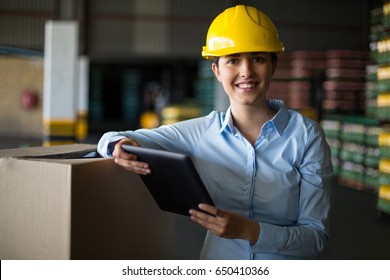 Portrait Of Female Factory Worker Standing With Digital Tablet In Factory